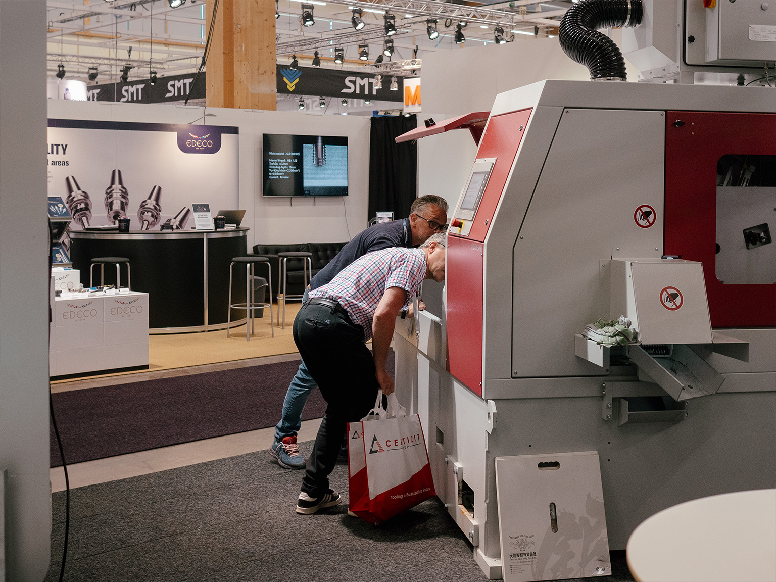 Kari Luokkala demonstrating the HCS circular saw to an interested customer at Elmia Machine Tools 2024